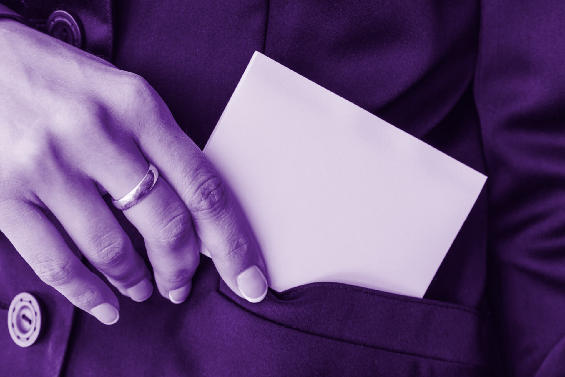 A female hand reaching for a business card in top jacket pocket