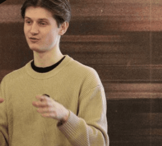 Testimonial photo of young man giving a talk on stage