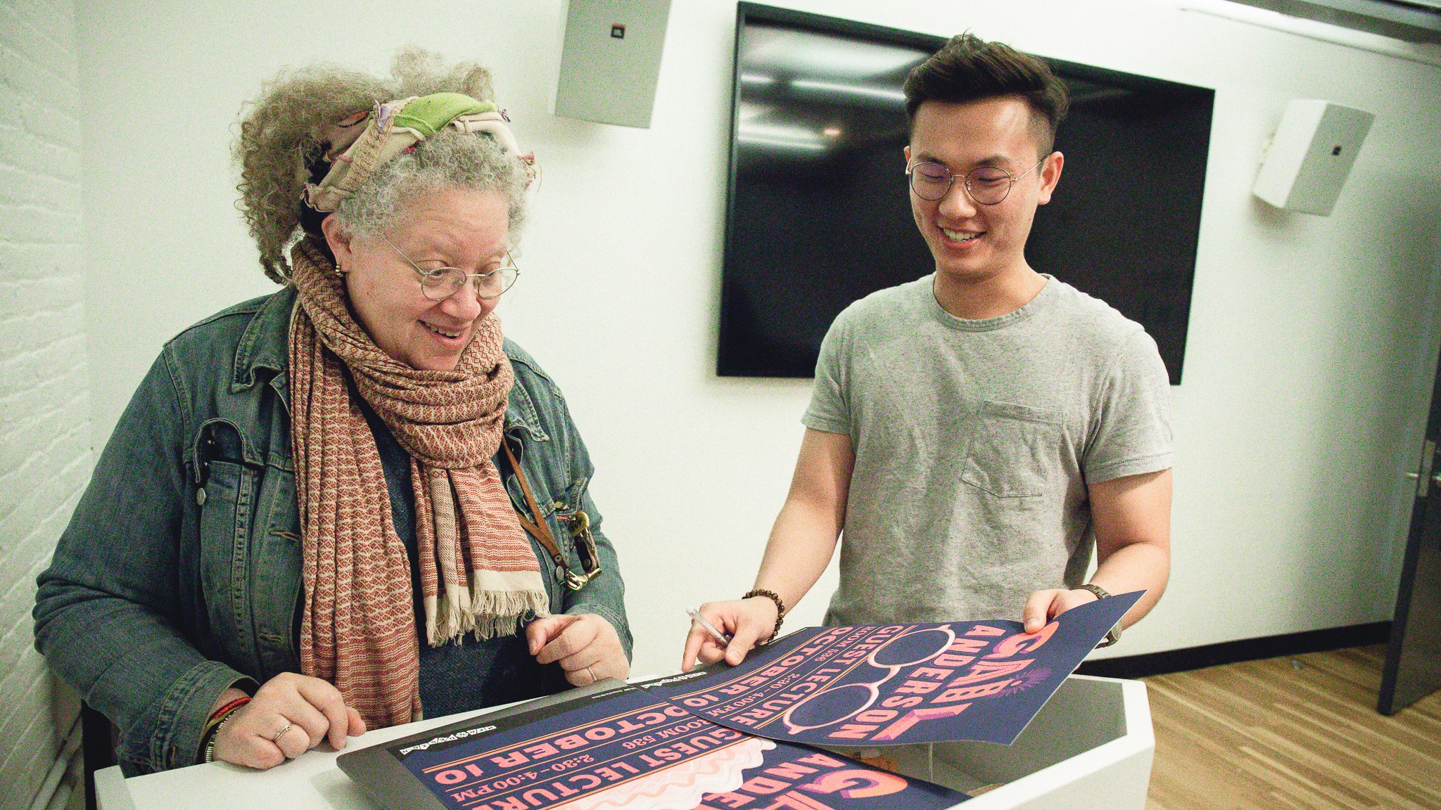 Bill Chien showing poster he designed for Gail Anderson's guest lecture