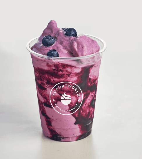 A purple smoothie topped with fresh blueberries and a sprinkle of frozen yogurt.