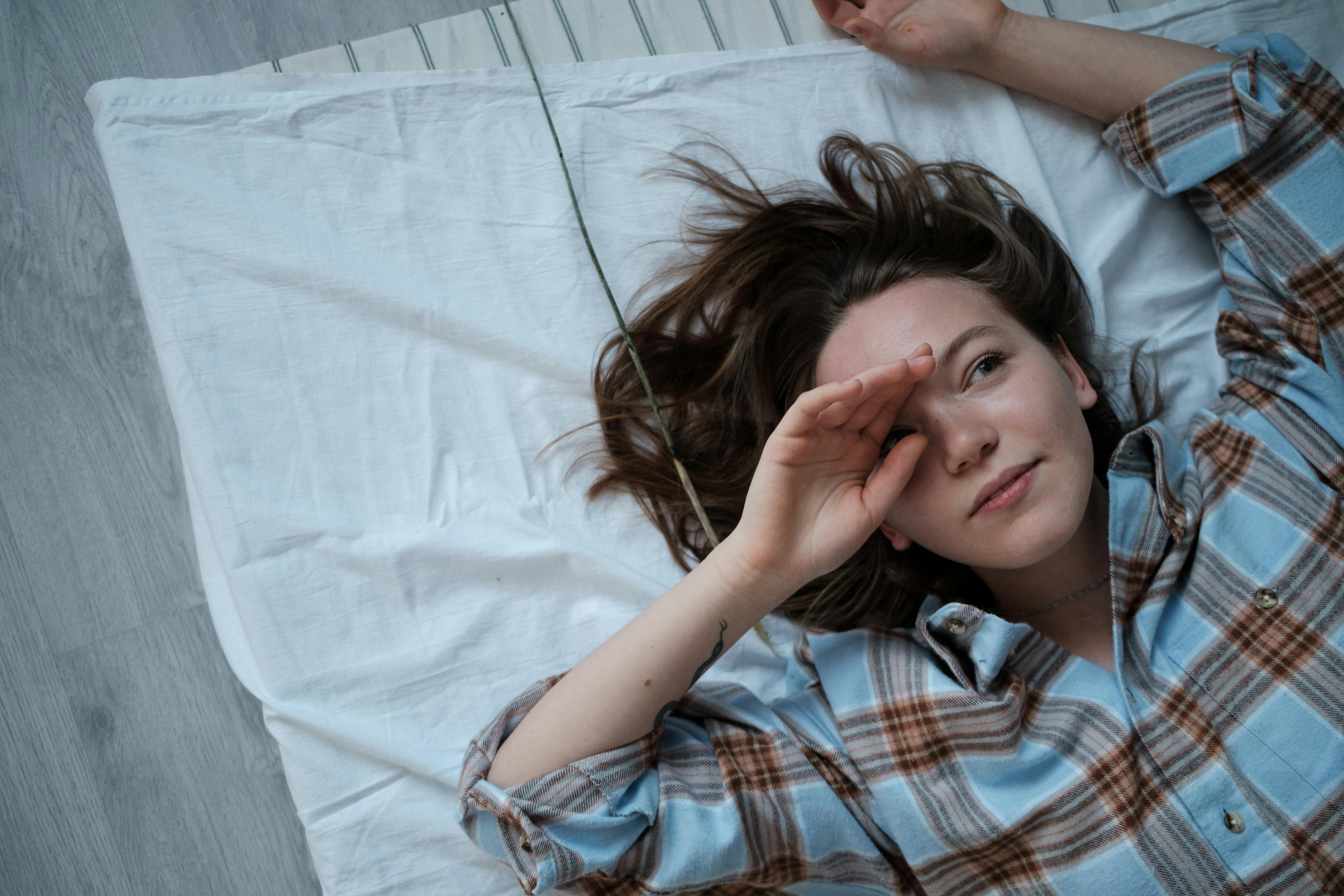 Top View of a Girl Wearing Checked Pyjama Lying Down on Matres