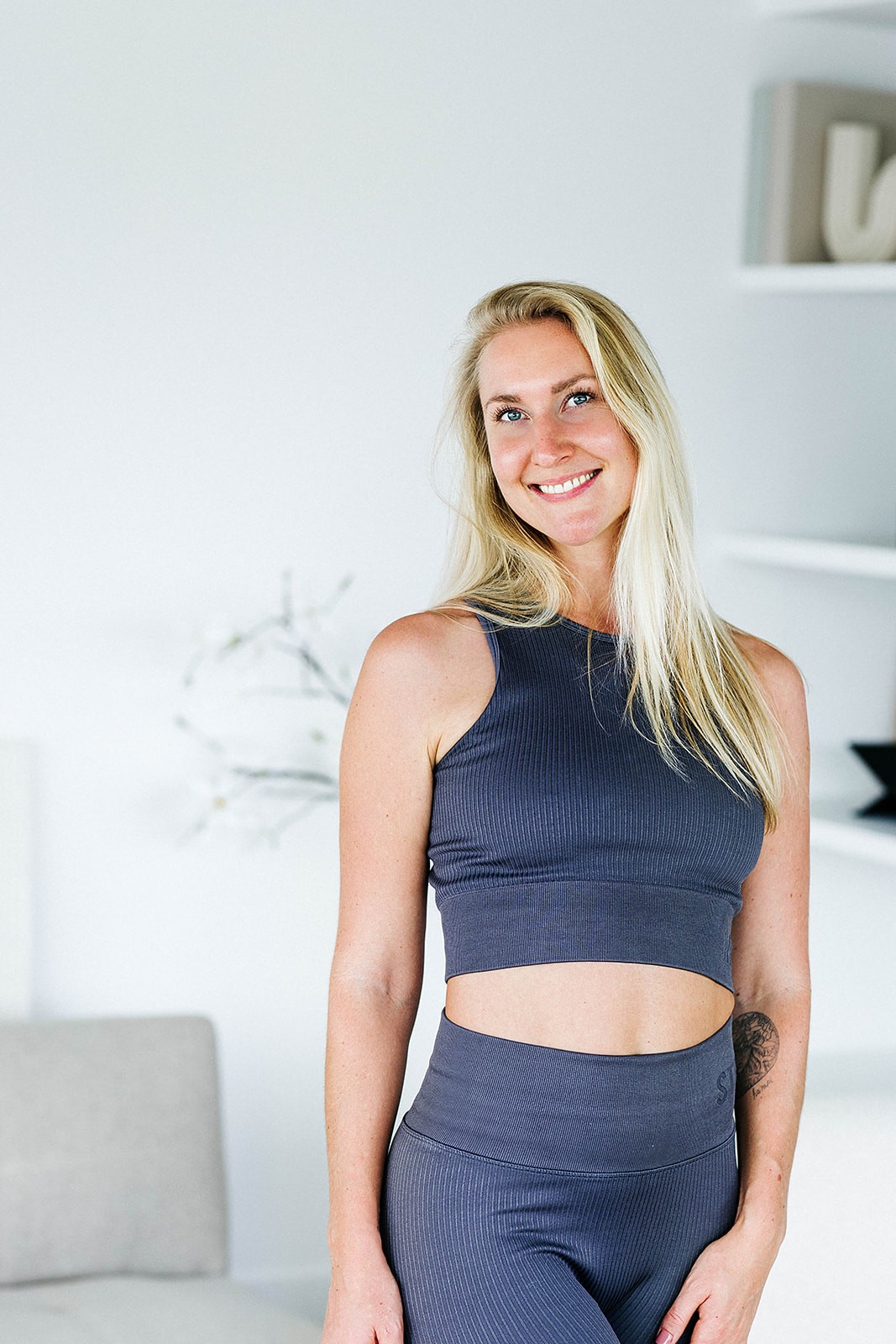 Vrouw die zich deels verschuilt achter een beige gordijn, symbool voor kwetsbaarheid en stilte rondom hormonale klachten