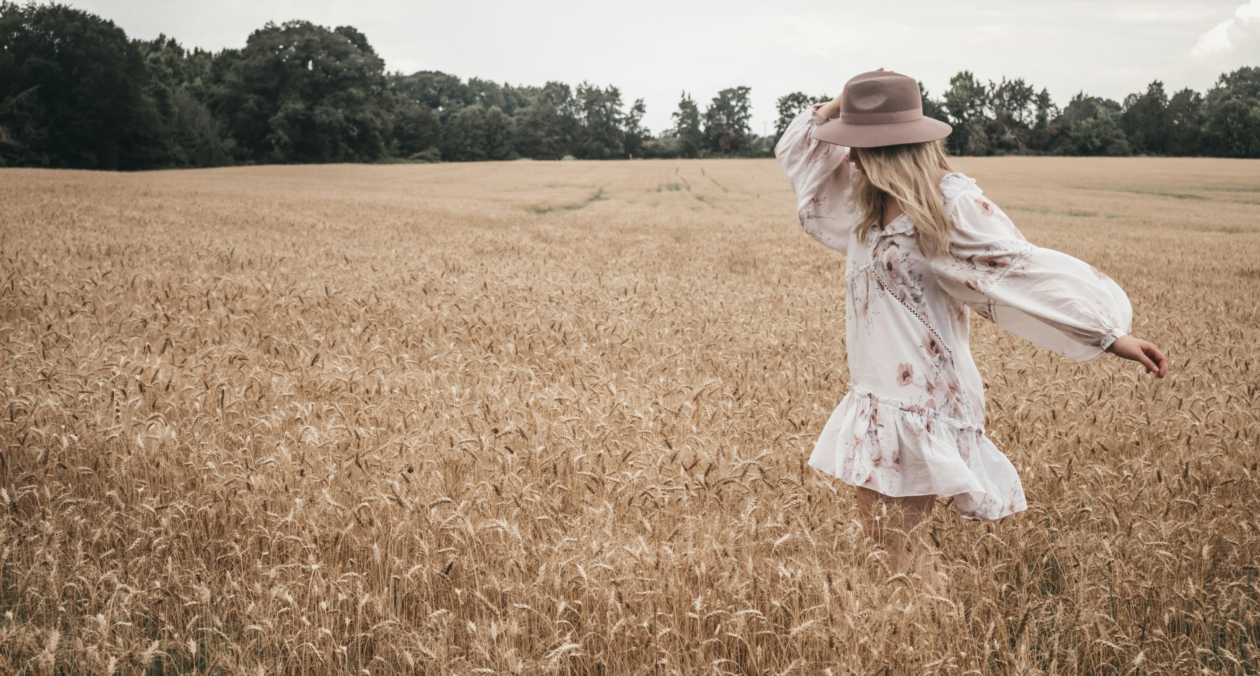 woman in pretty bohemian dress in field of wheat