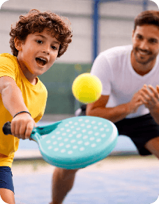 Kid playing padel with coach
