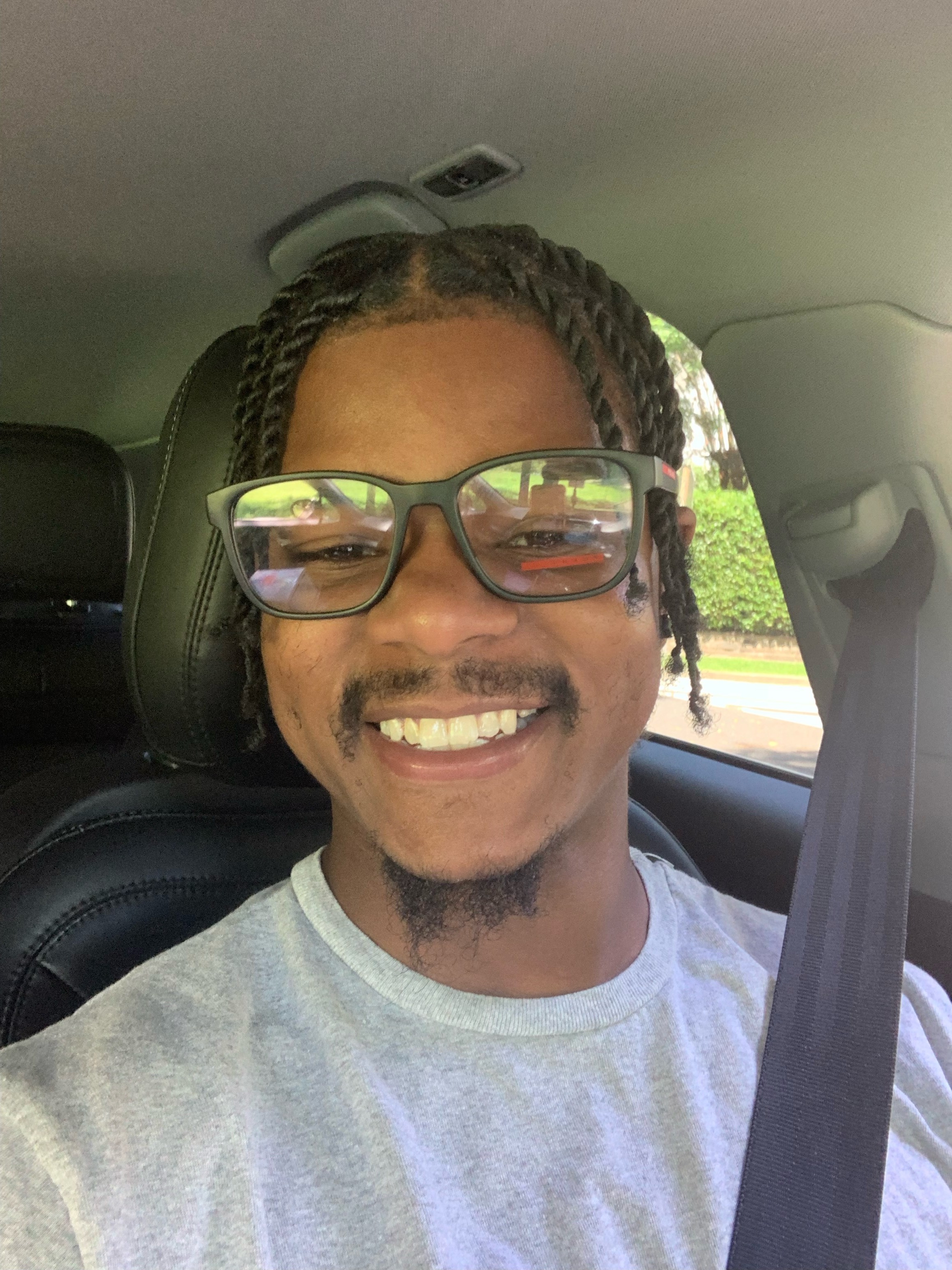 Portrait of a man with medium-length dark hair and a white shirt, set against a neutral background.