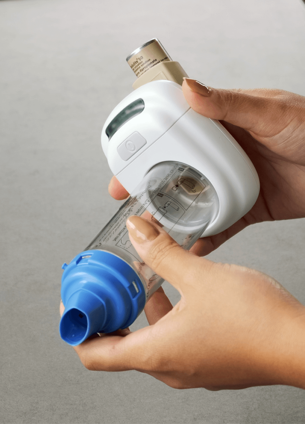 Close-up of a hand holding a smart inhaler device used for respiratory monitoring.