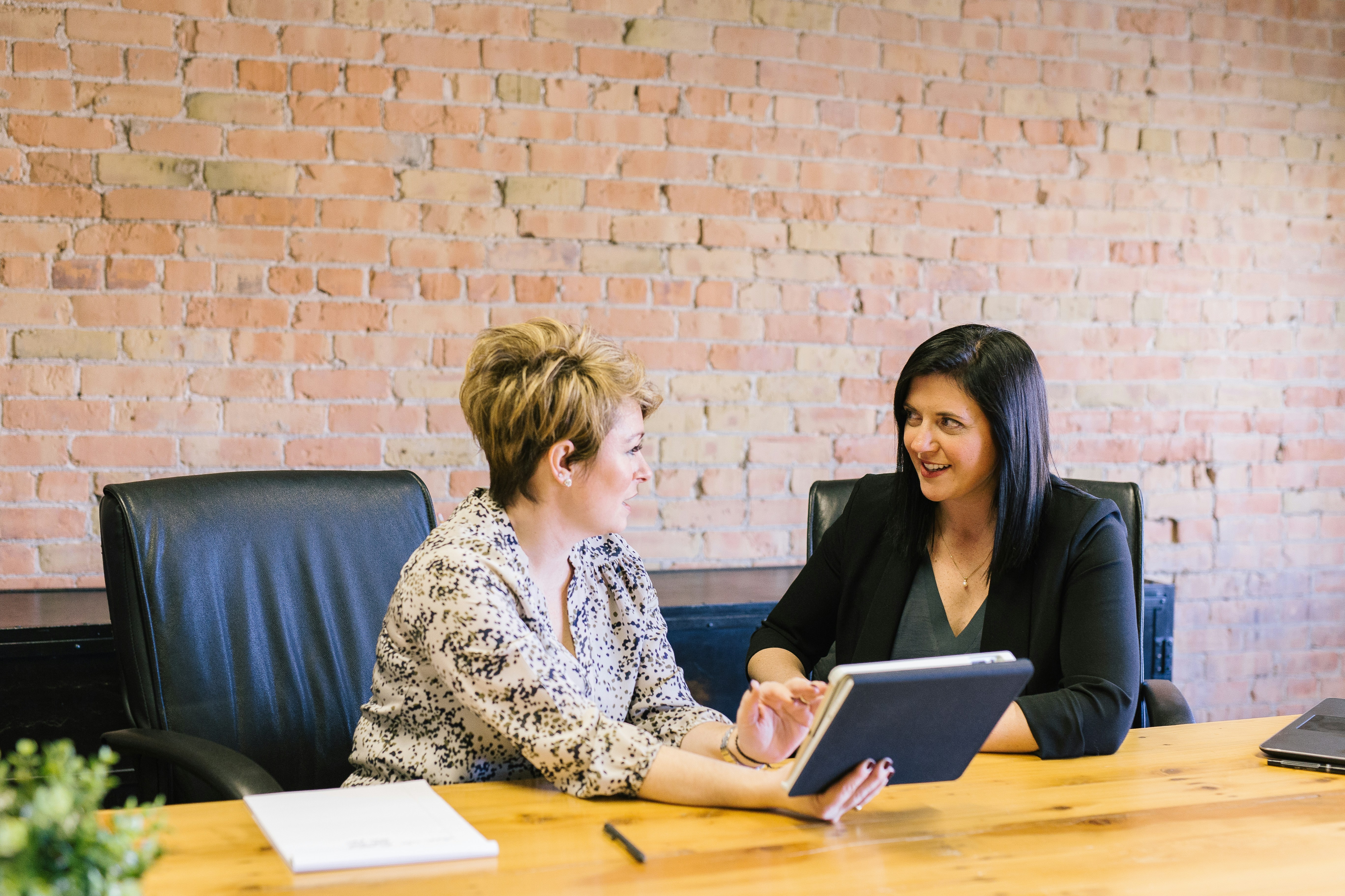 A photographer showing her portfolio of creative headshots to a client 