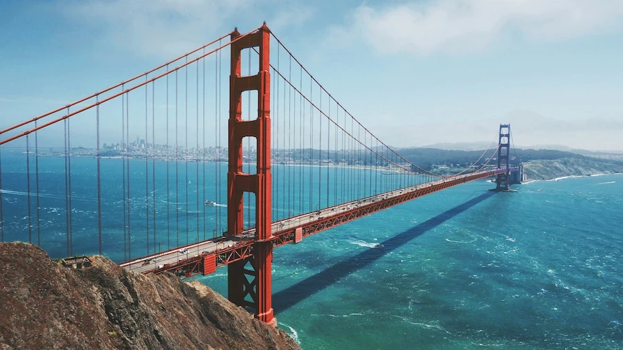 Golden Gate Bridge spanning San Francisco Bay, United States, with turquoise water and coastal hills.