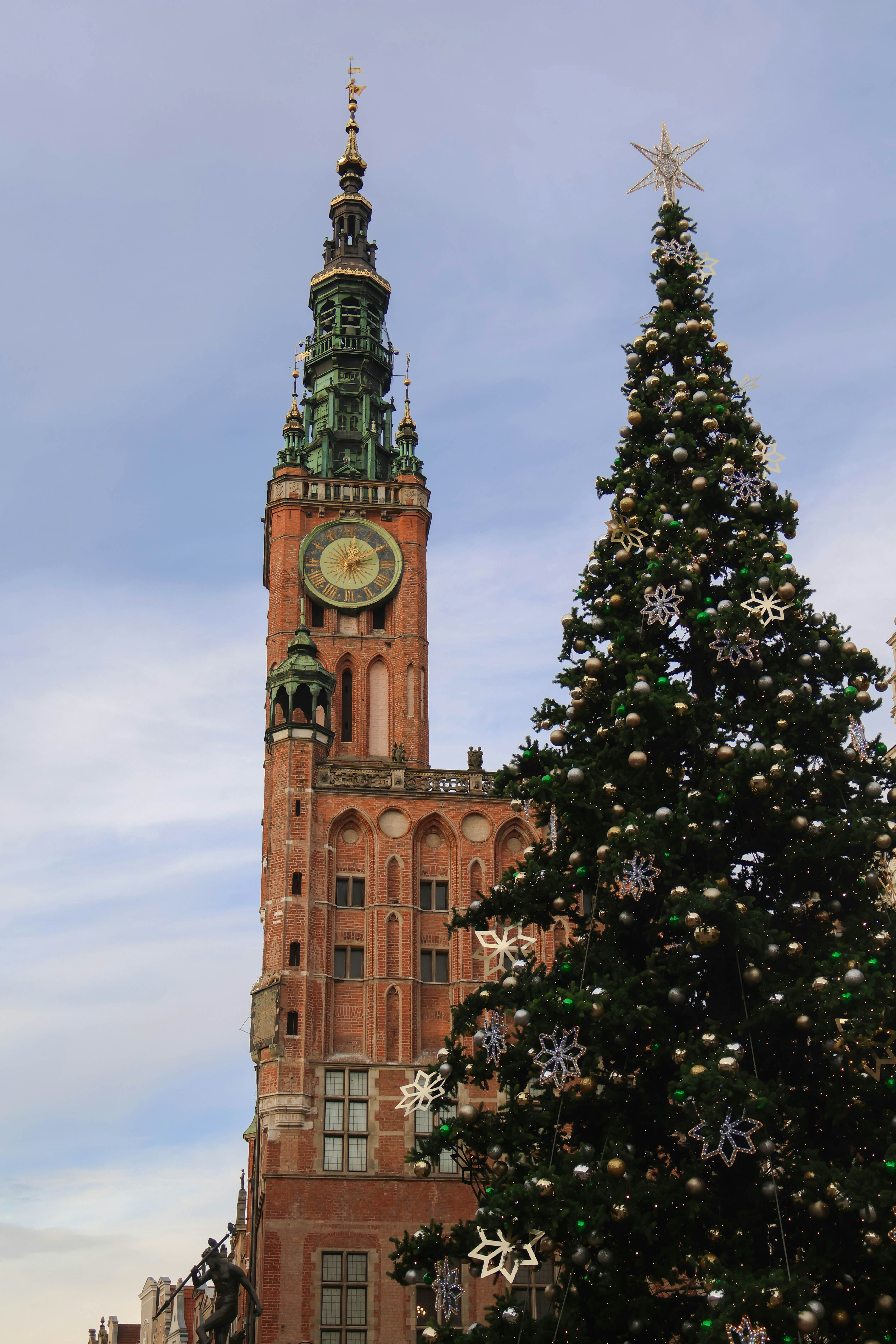 A large christmas tree in front of a tall building