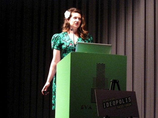 a woman in a green dress is giving a speech at the stand