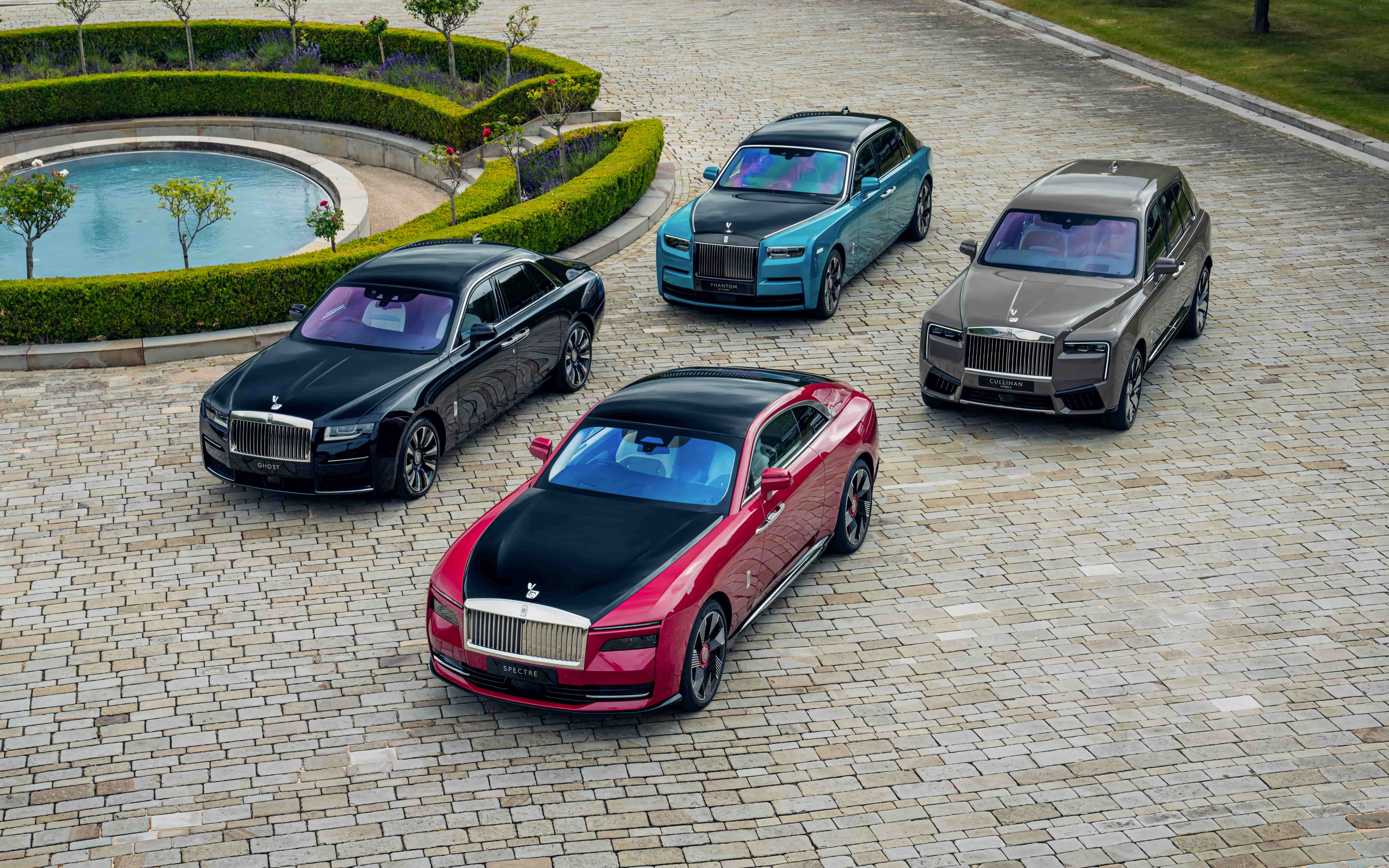 Multiple Rolls-Royce Spectre vehicles parked outdoors in a luxury setting