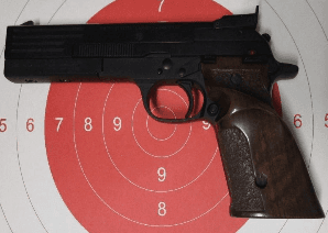 Beretta 89 pistola semiautomatica di precisione calibro .22 Long Rifle con impugnatura in legno e canna da 6 pollici, fotografata su sfondo neutro