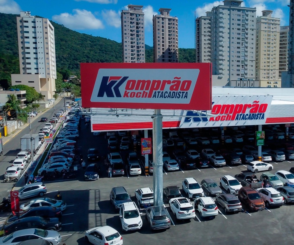 Black and white image of people working at a table with laptops, showing hands gesturing during discussion of digital content displayed on screens, with fabrica® logo in the corner.
