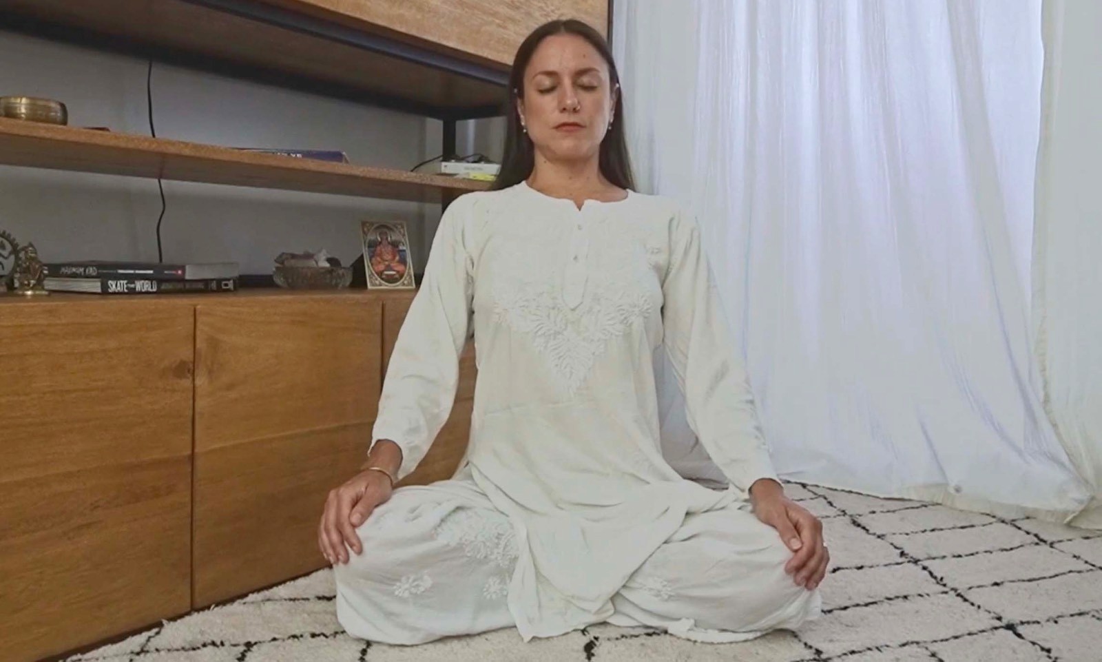 Flavia Siutti sentada en postura de meditación con manos sobre las rodillas practicando respiración consciente.