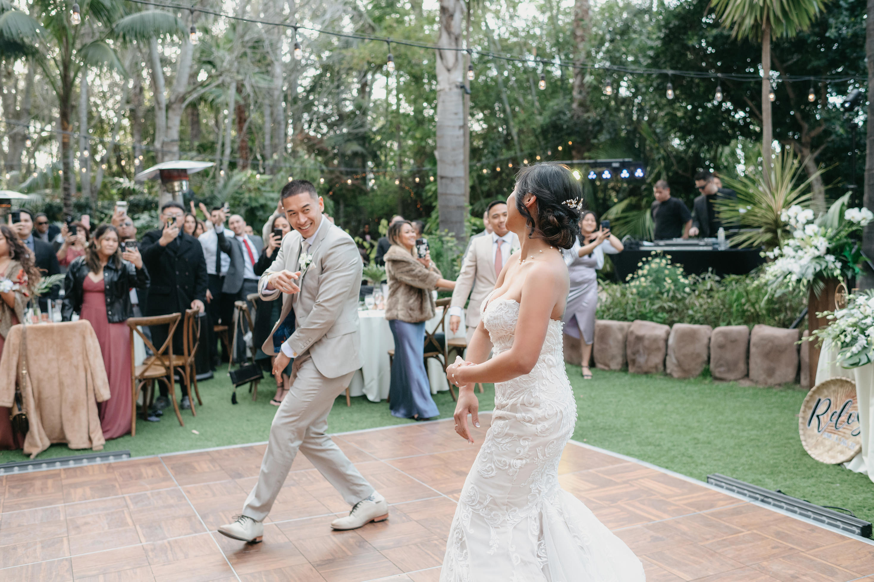 Bride and groom first dance with guests cheering