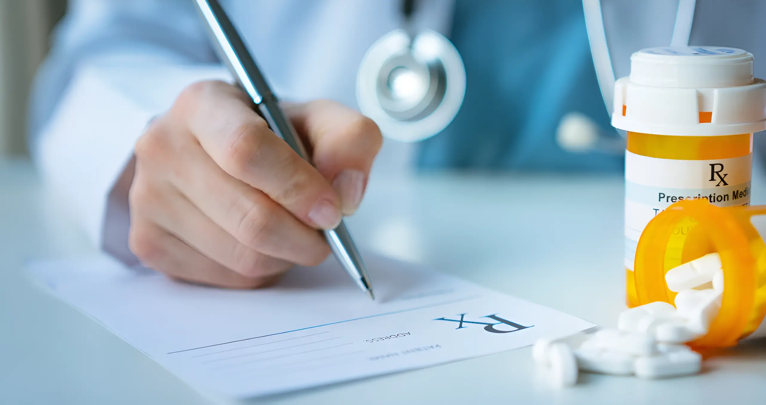 Doctor writing a medical prescription next to a bottle of tablets.