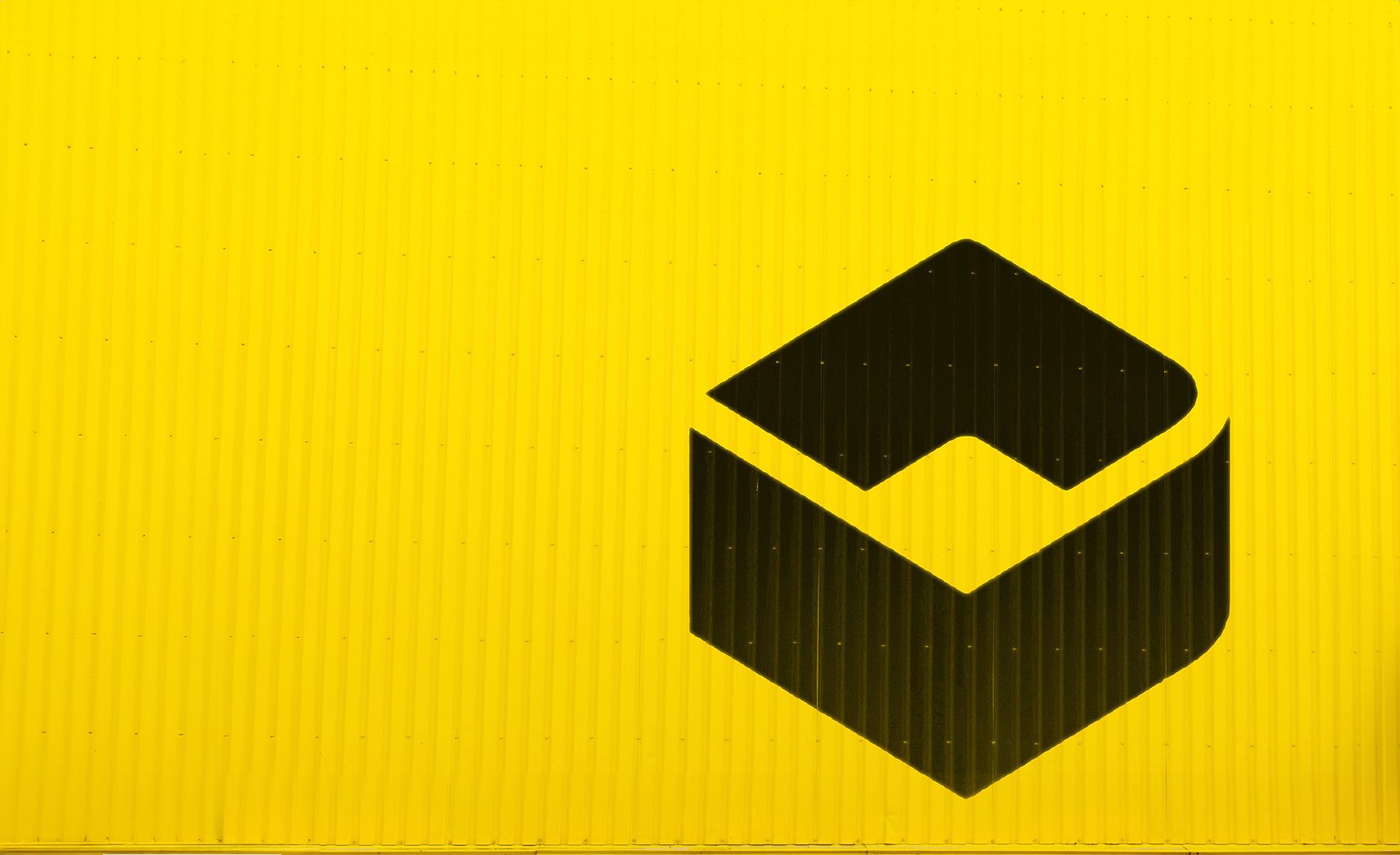 Bold black geometric shape on a vibrant yellow corrugated metal surface. The contrast is striking, evoking a modern and industrial feel.