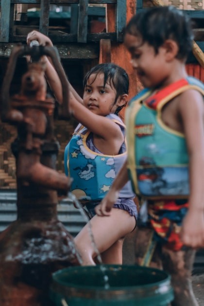 Children collecting clean water at a hand pump