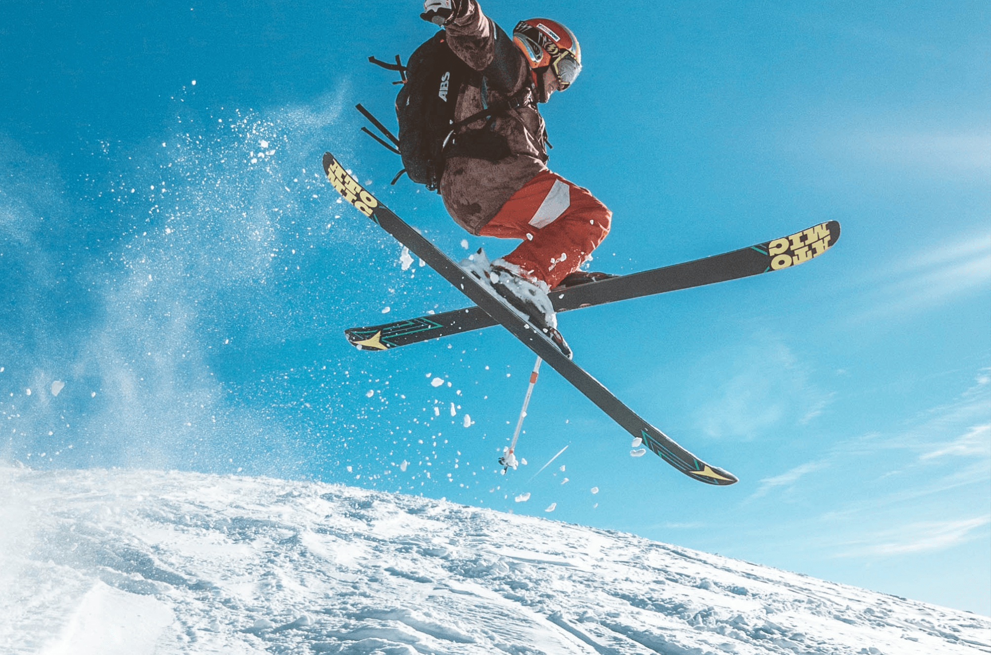 A person in midjump on a snowy mountain