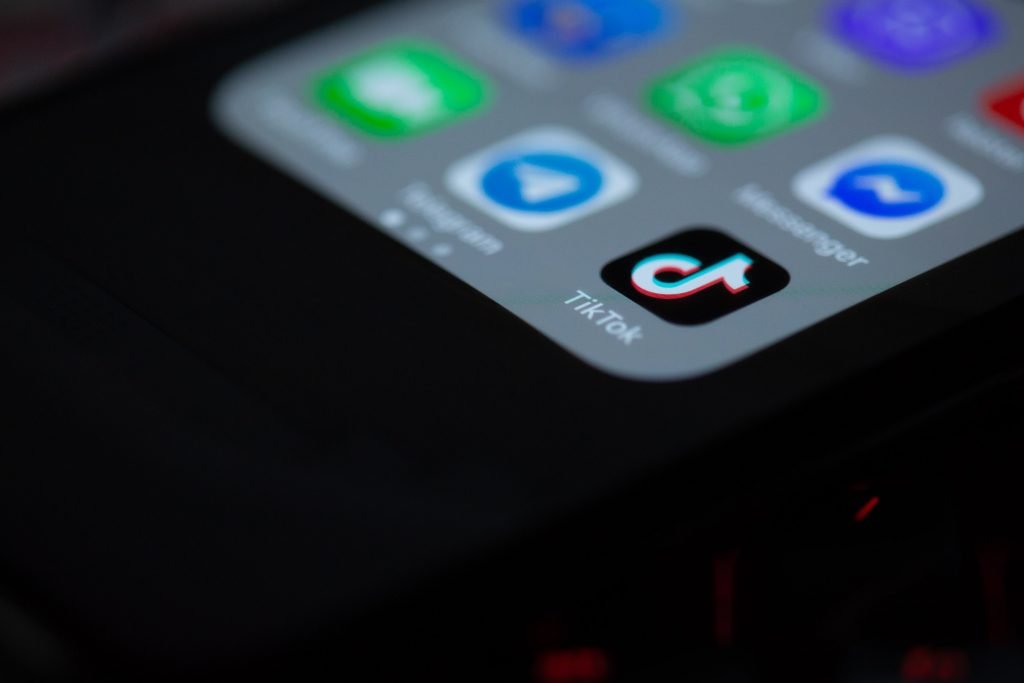 TikTok app icon on a smartphone home screen next to Telegram and Messenger