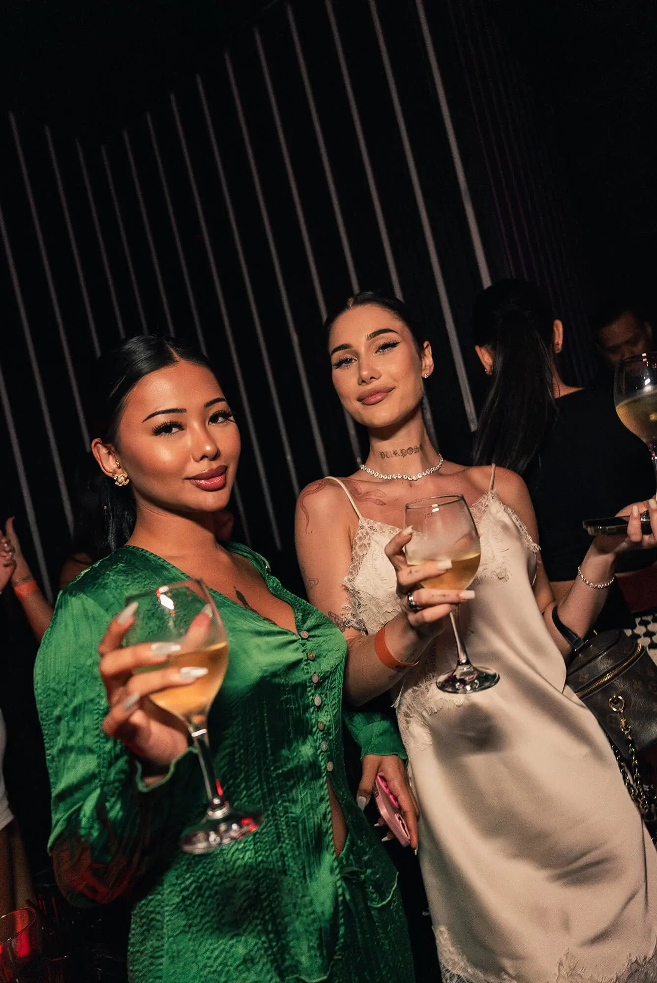 Two guests raising glasses of wine at The Myth Dubai