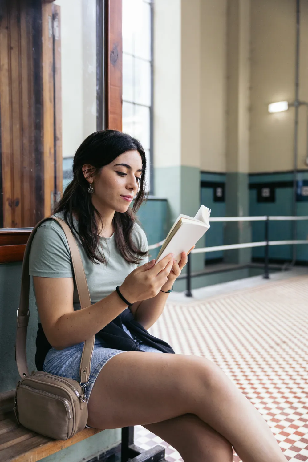 Woman reading sat on a bench