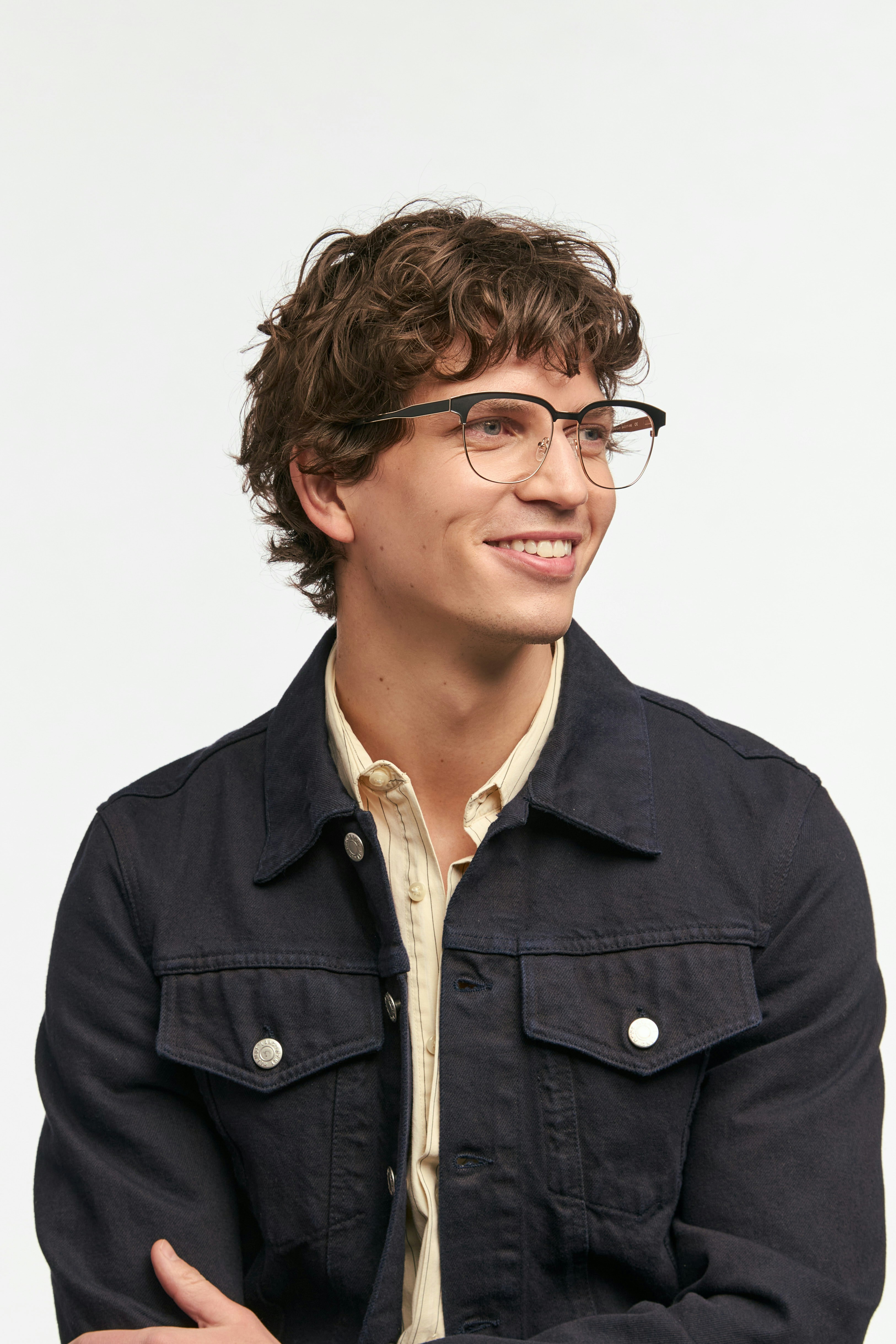 Man with curly hair wearing glasses and jacket