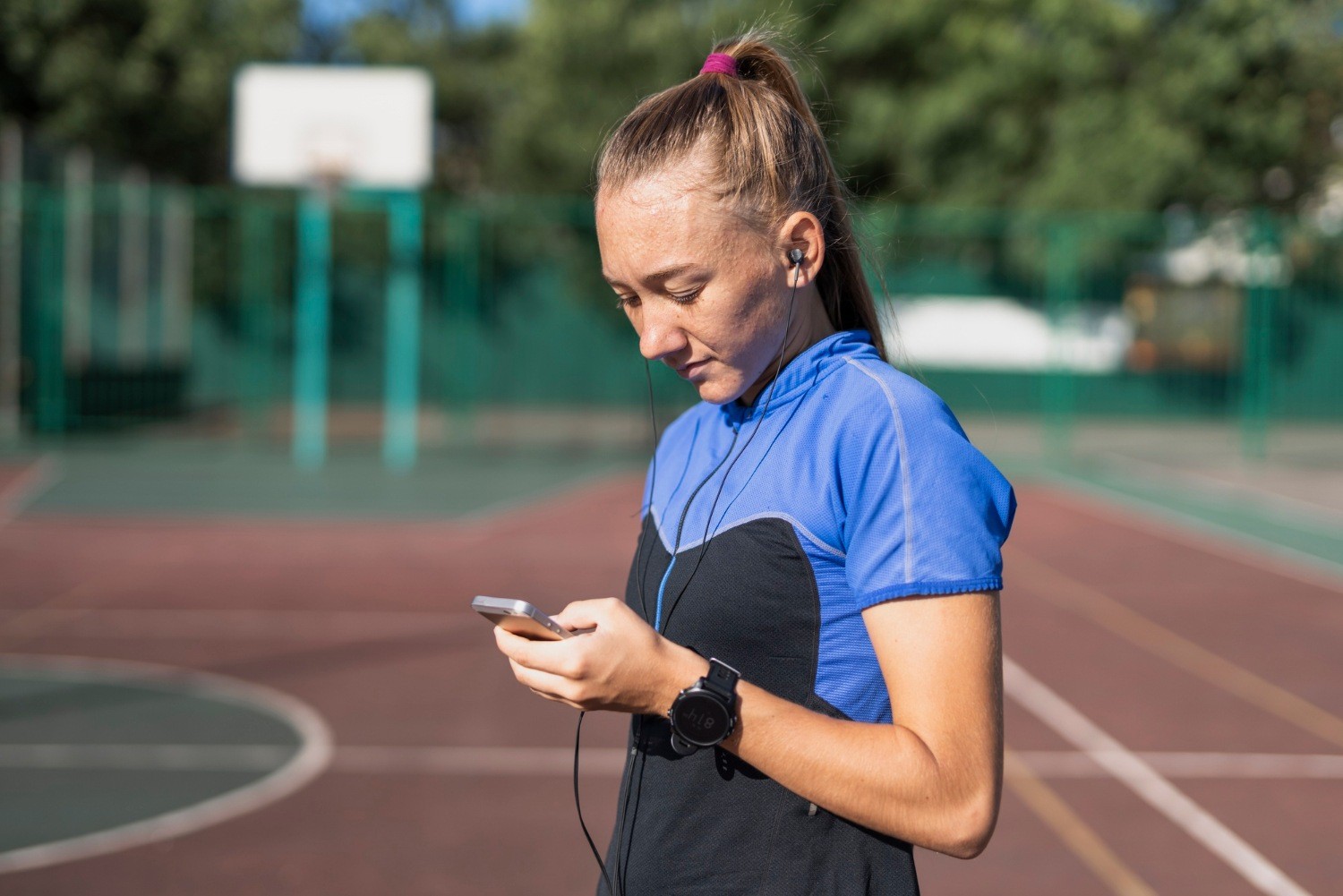 Biegaczka analizująca dane treningowe w aplikacji na telefonie po treningu