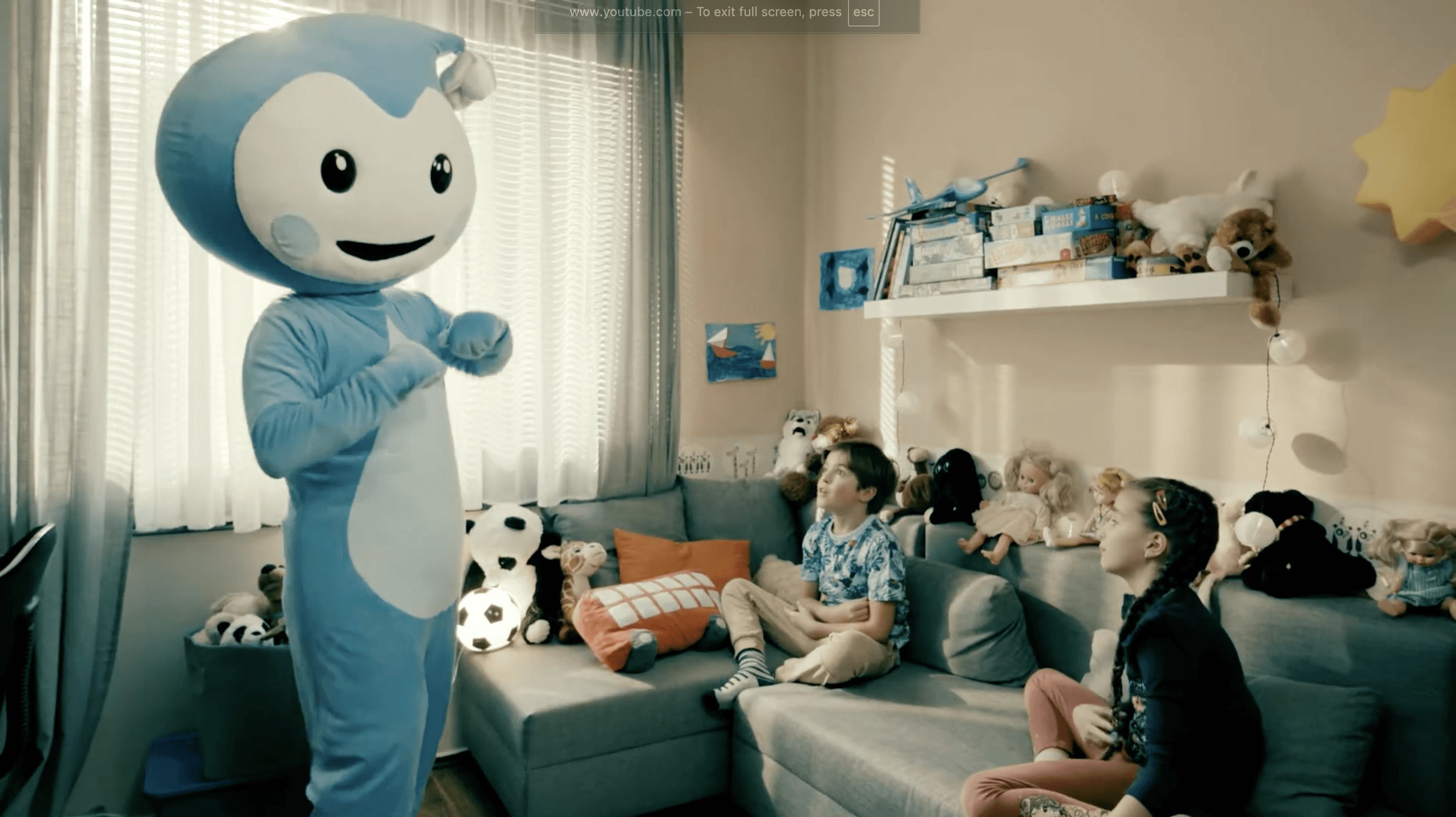 Cseppbarát kék kabalafigurája énekel a gyerekekkel a nappaliban