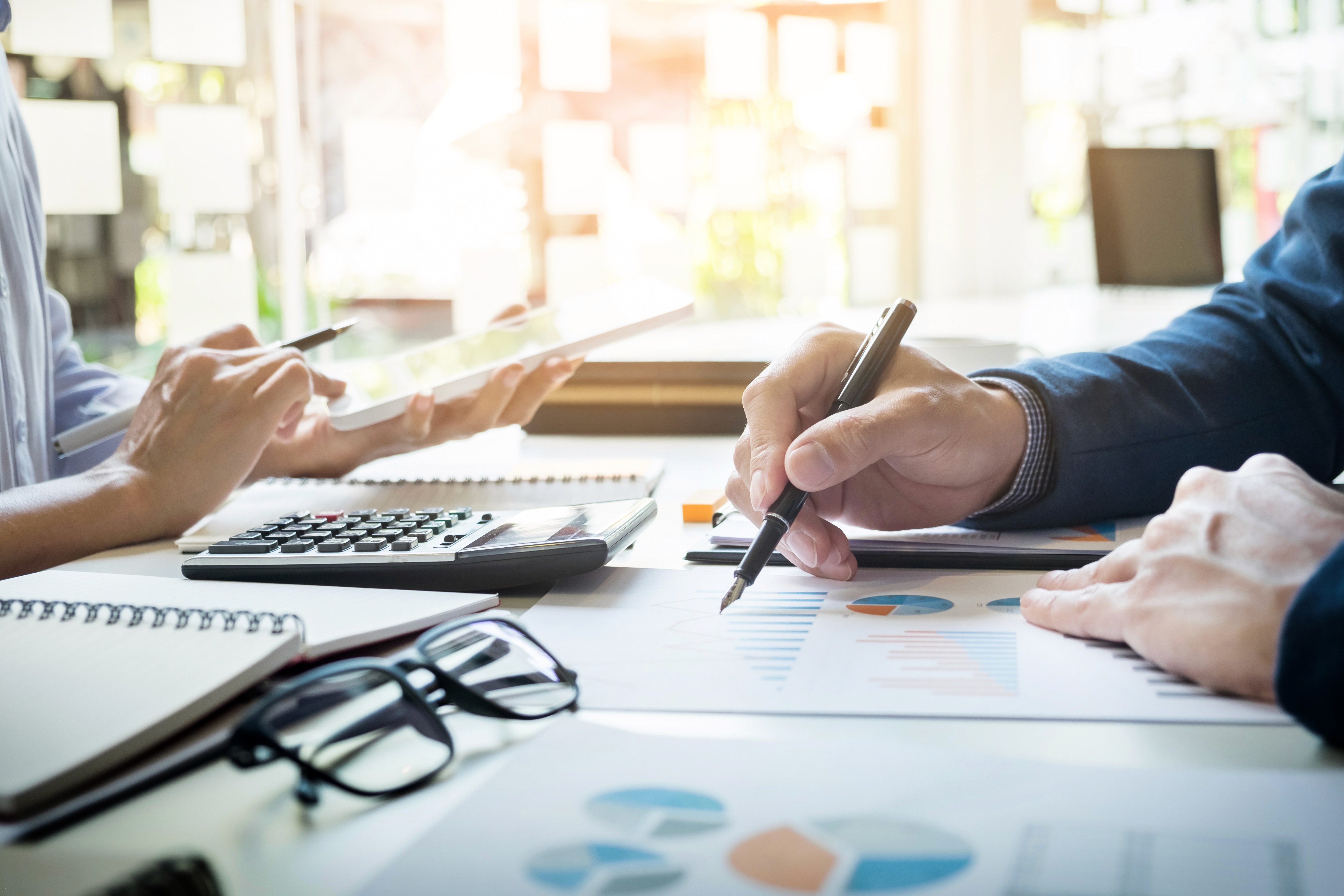 Business professionals reviewing financial charts and data at a desk.