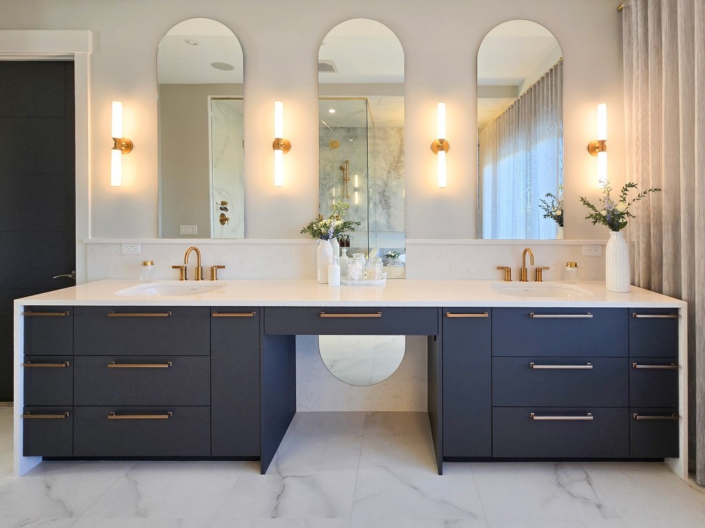 Image of Luxury bathroom design with double vanity, gold fixtures, and marble tiles by KHD Homes.