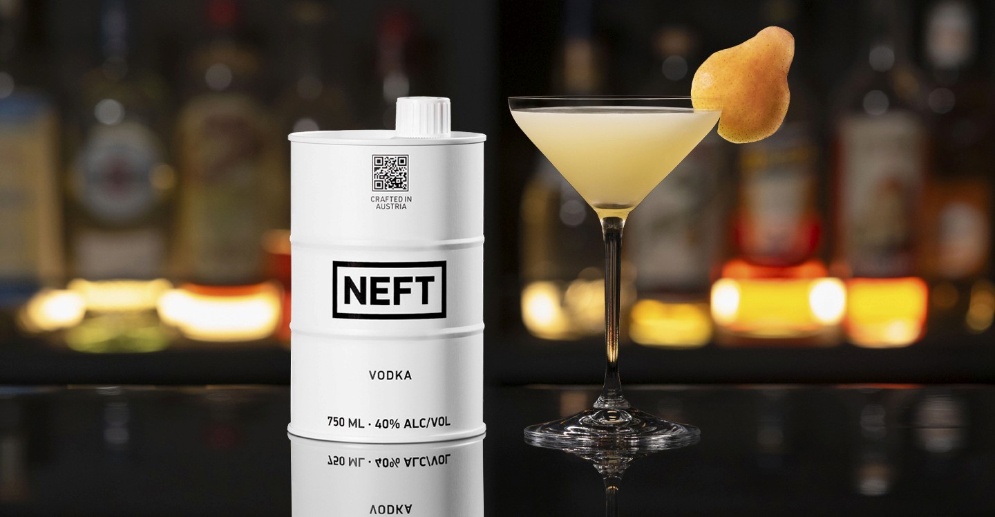 A NEFT Barrel and a glass of Pear Martini on a bar counter.