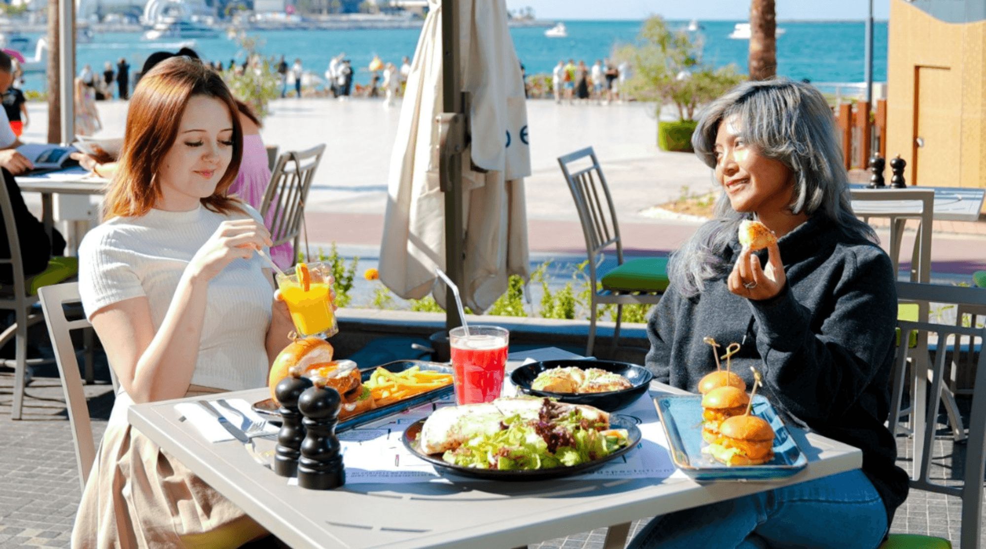 Two people are sitting outside a breakfast place in Dubai and eating.