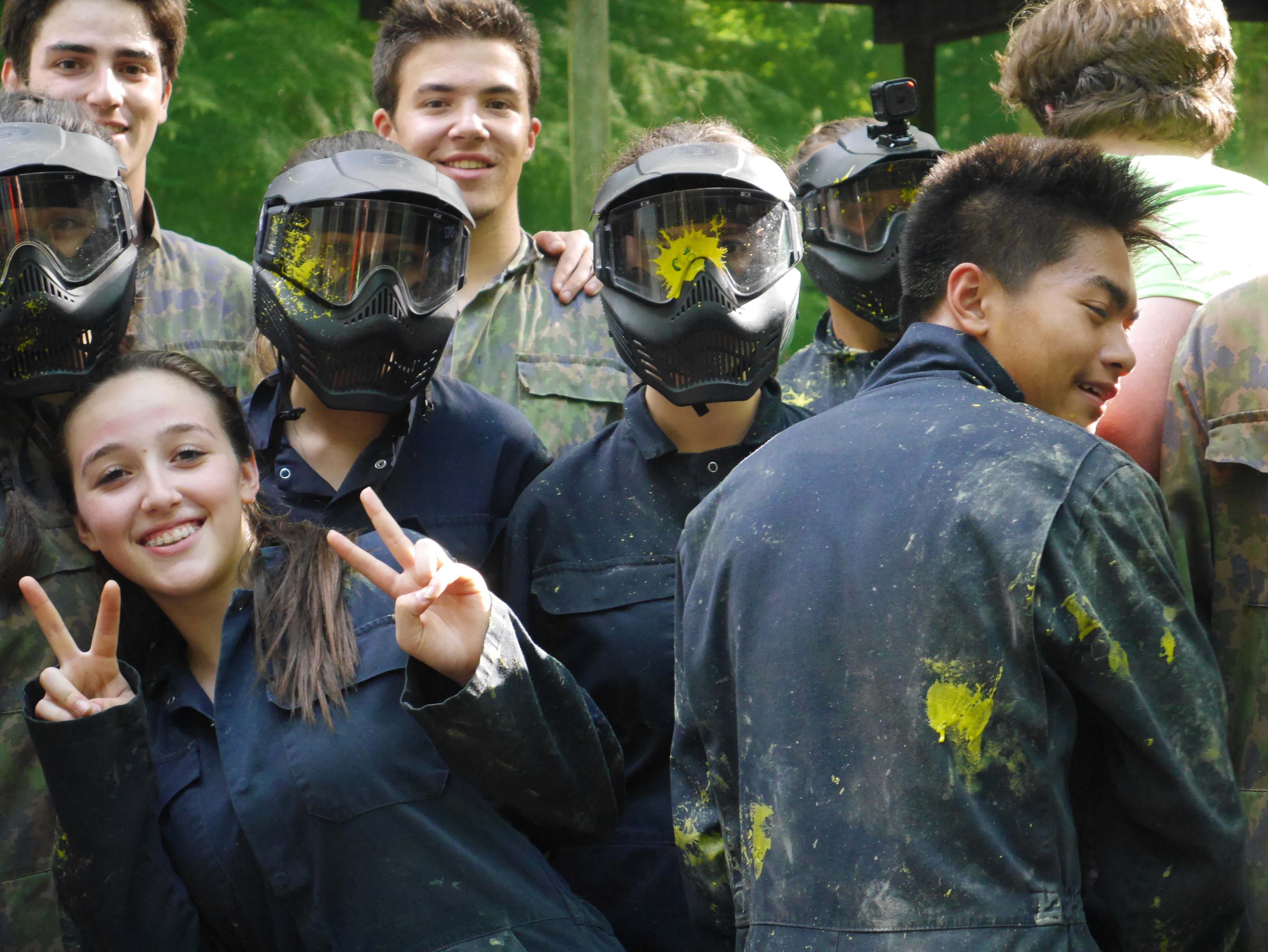 Two women arriving at a doorway, greeted by another woman.