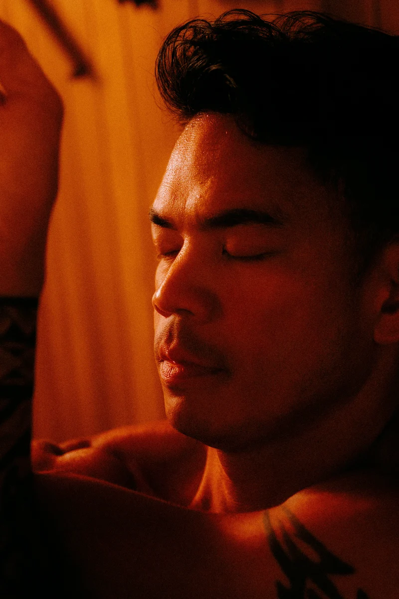 Close-up of a person with eyes closed in a warm, softly lit space during a guided meditative session in Vancouver.