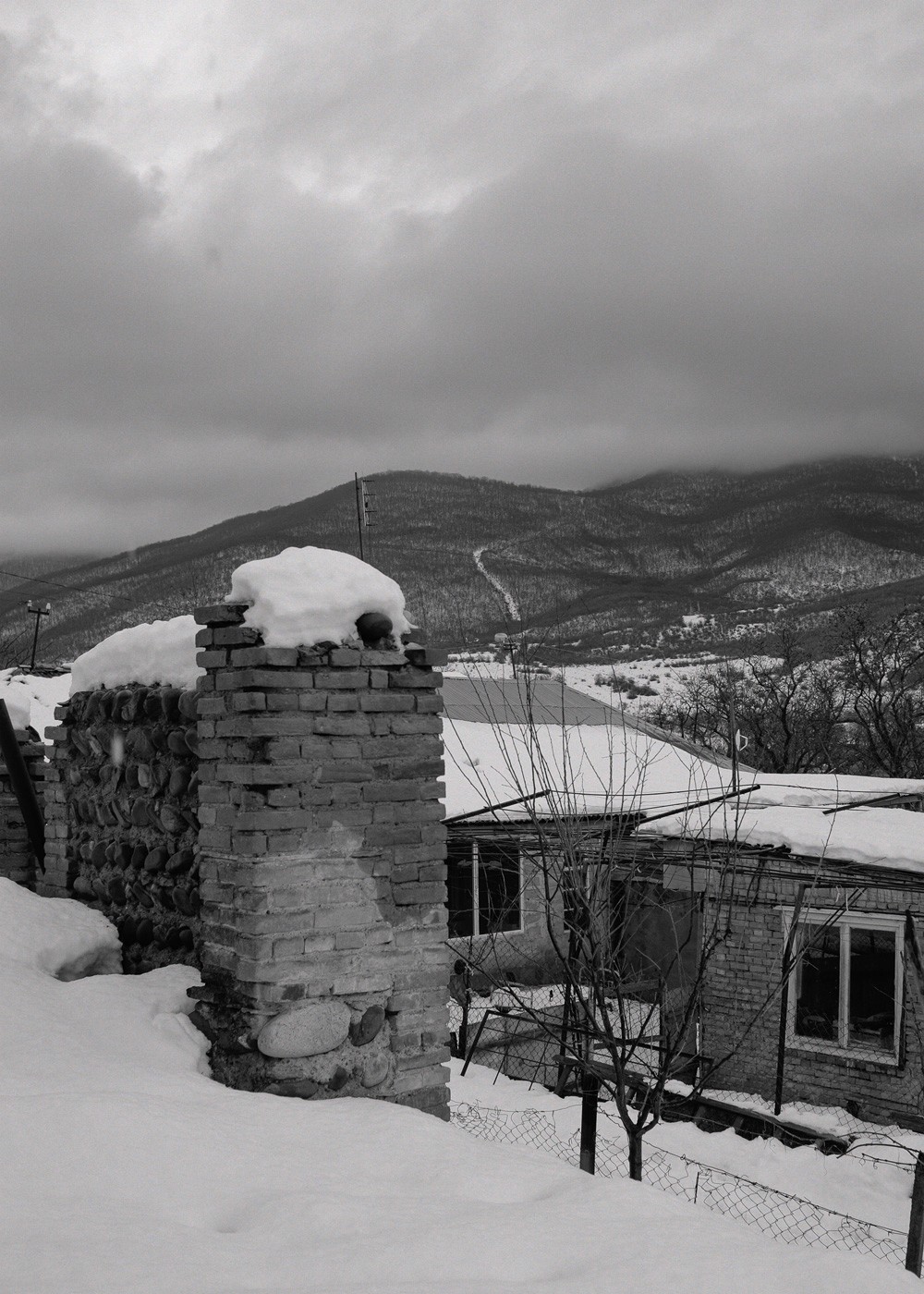 Snow-covered road and mountains viewed from the window of a house near the occupation line in Georgia