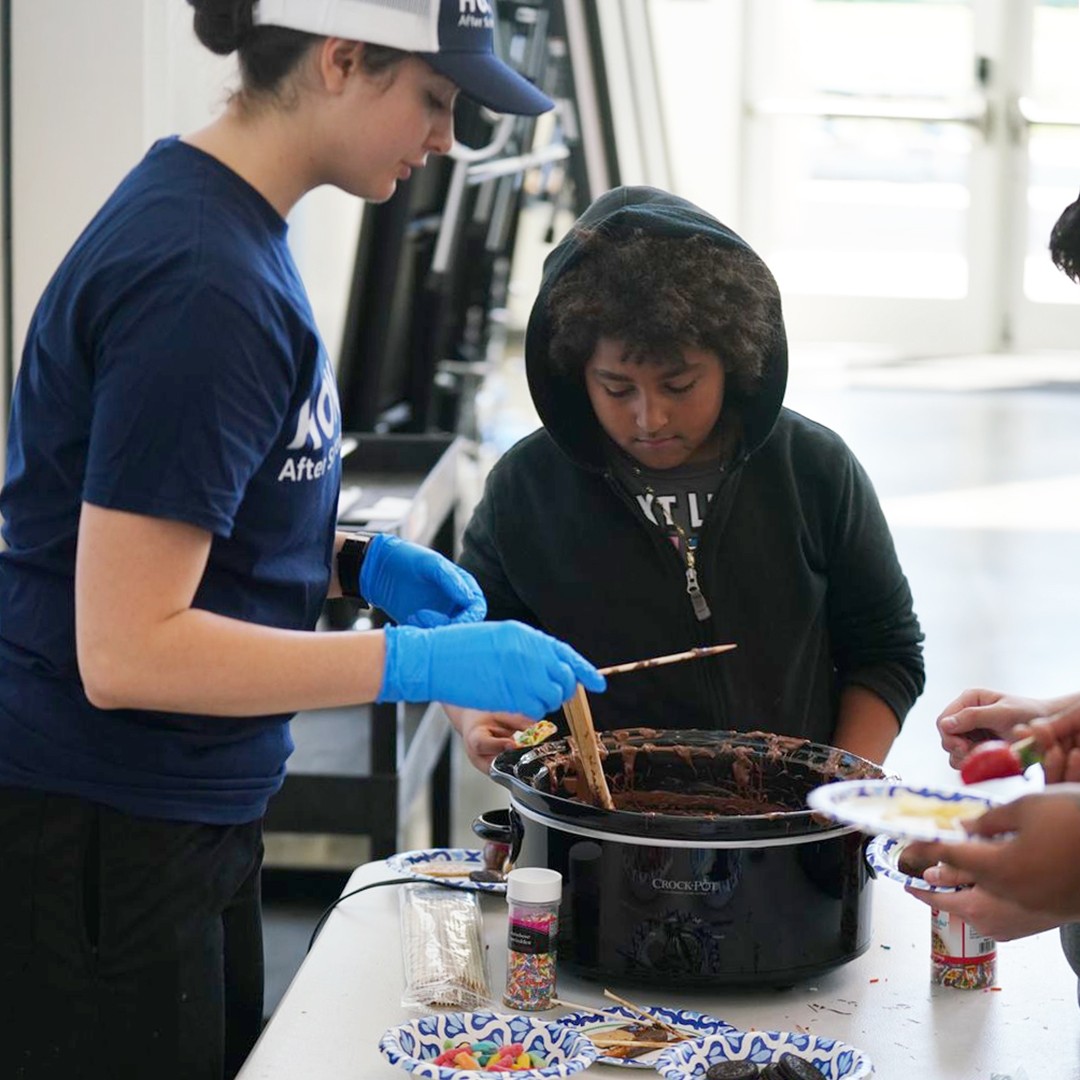 Young chefs practicing food preparation techniques in interactive culinary workshop