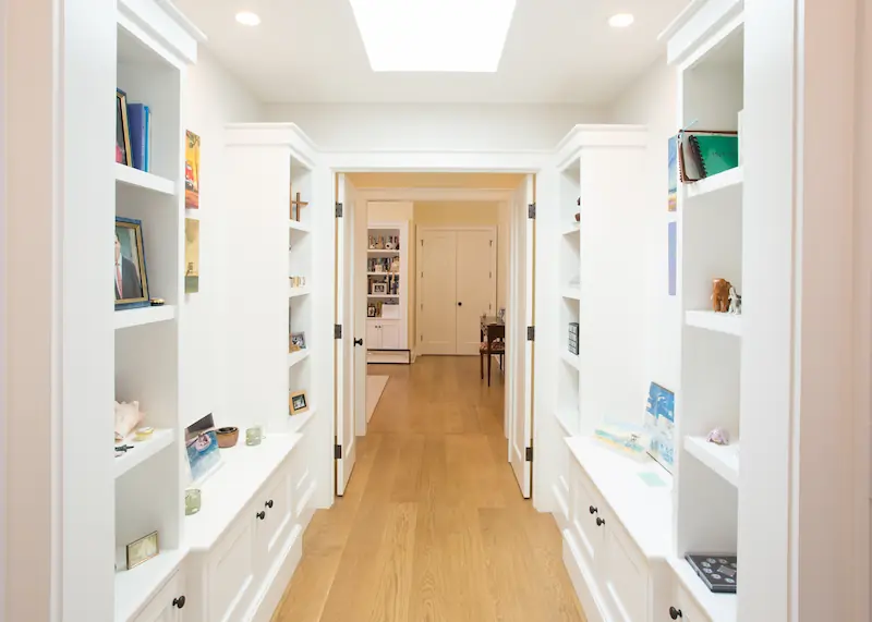 Spacious hallway with skylight and galley style built-in cabinetry and hardwood floors from the Big Canyon Remodel project. Photo by Chris Darnall.