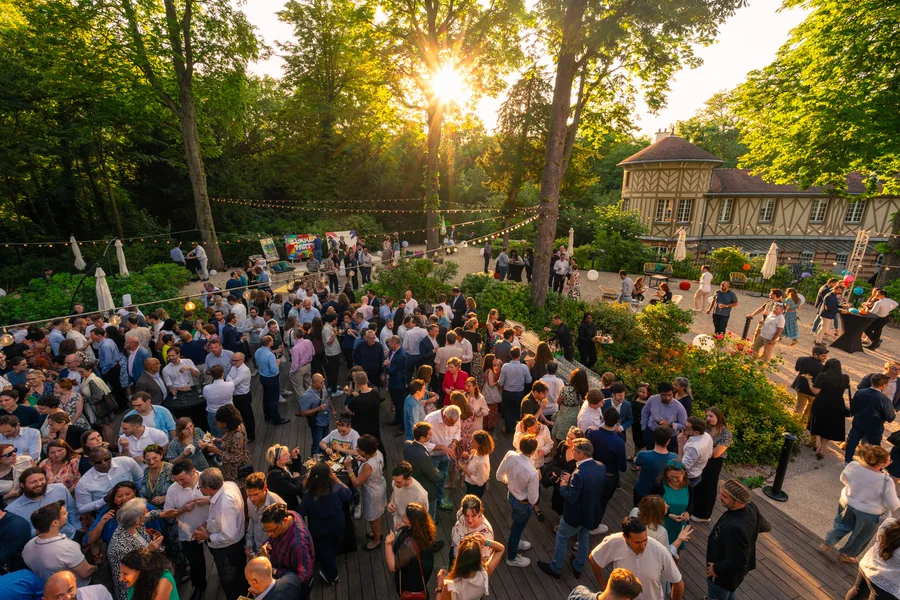 Vue d’ensemble des participants à un cocktail en extérieur au Pavillon Royal, à Paris.