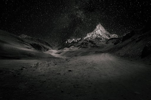 A black sand beach with mountains in the distance