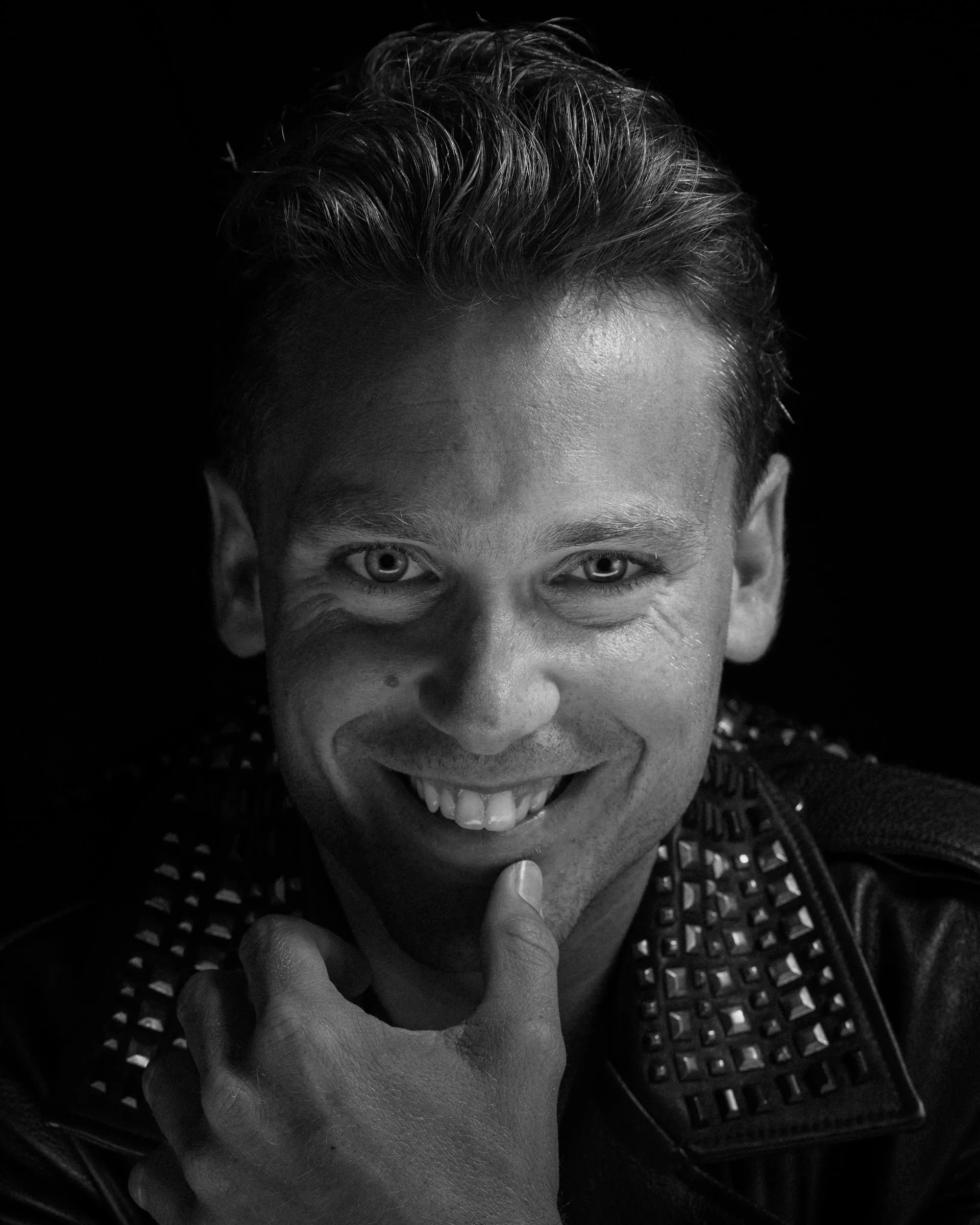 A charismatic black and white portrait of Bastian Baker smiling during a shoot.