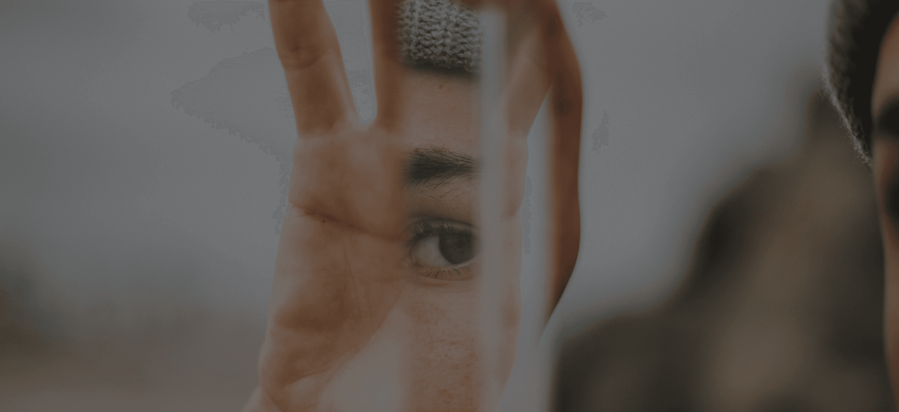 Person looking through a blurred glass surface, soft natural light.