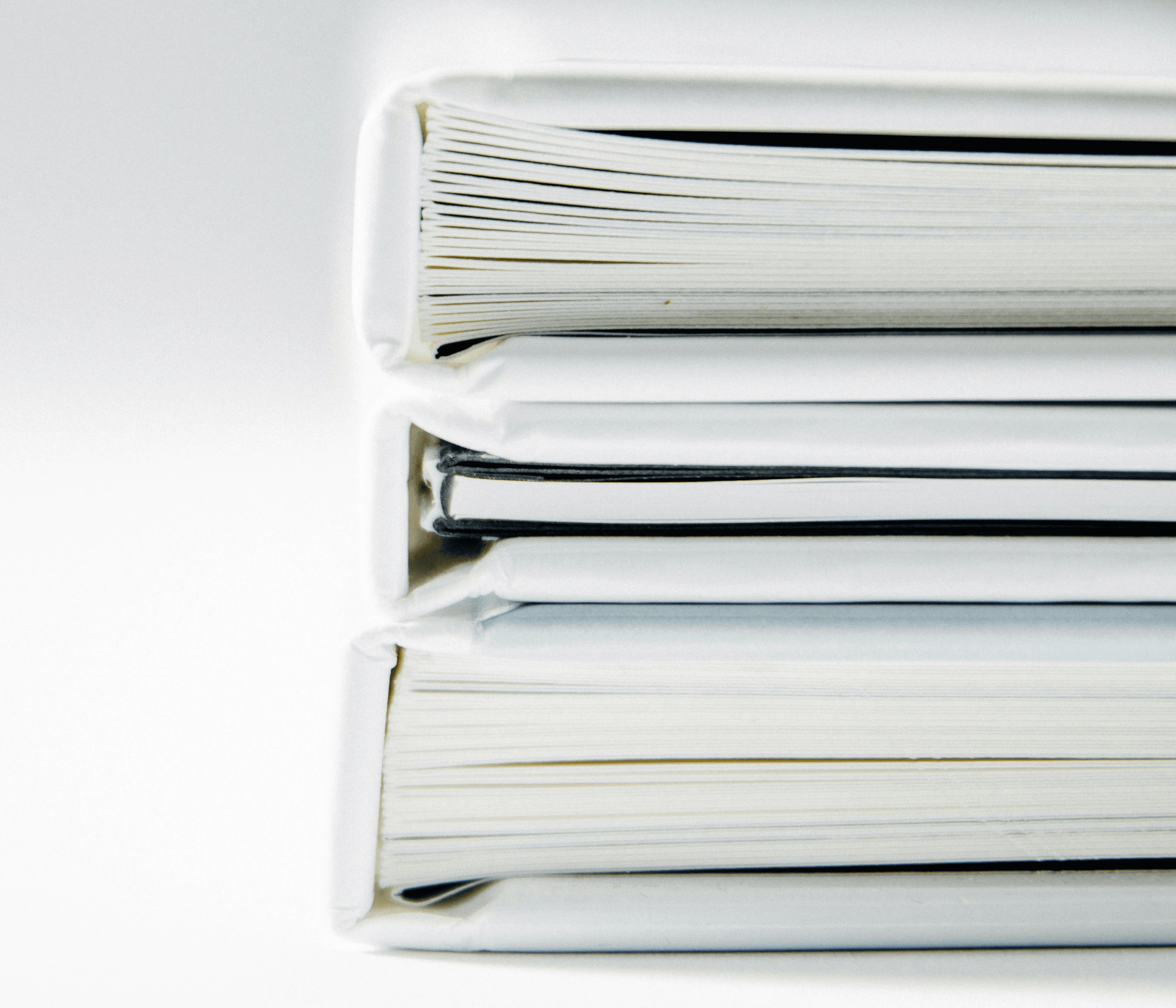 A stack of thick folders on a white surface