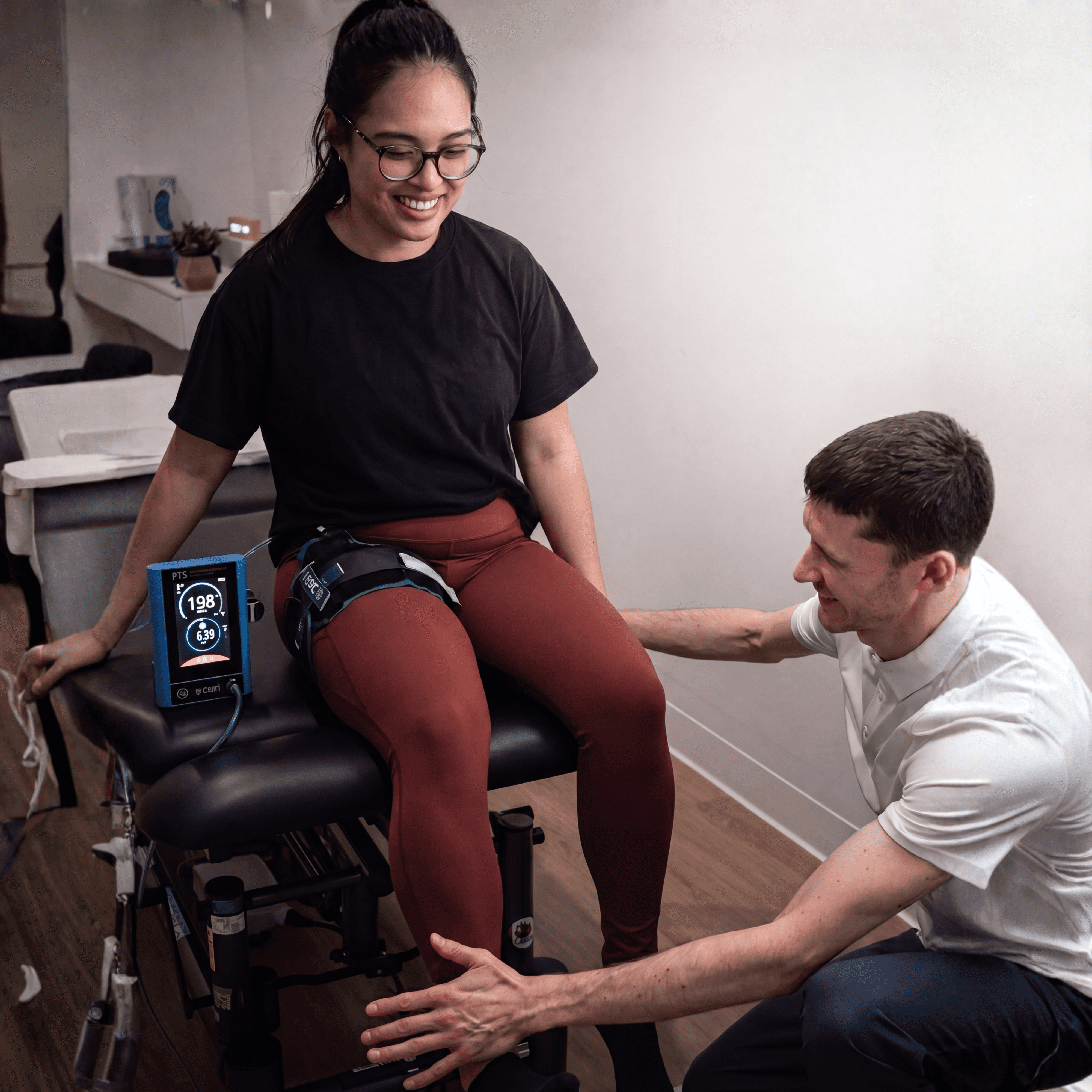 Physiotherapist guiding seated patient through a bloodflow restritction exercise