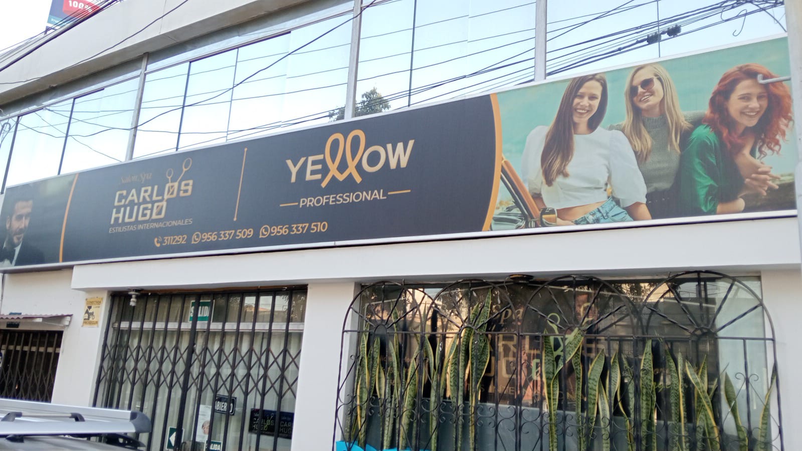 Exterior de Peluquería Carlos y Hugo Spa en Arequipa, con la puerta de entrada y los banners visibles