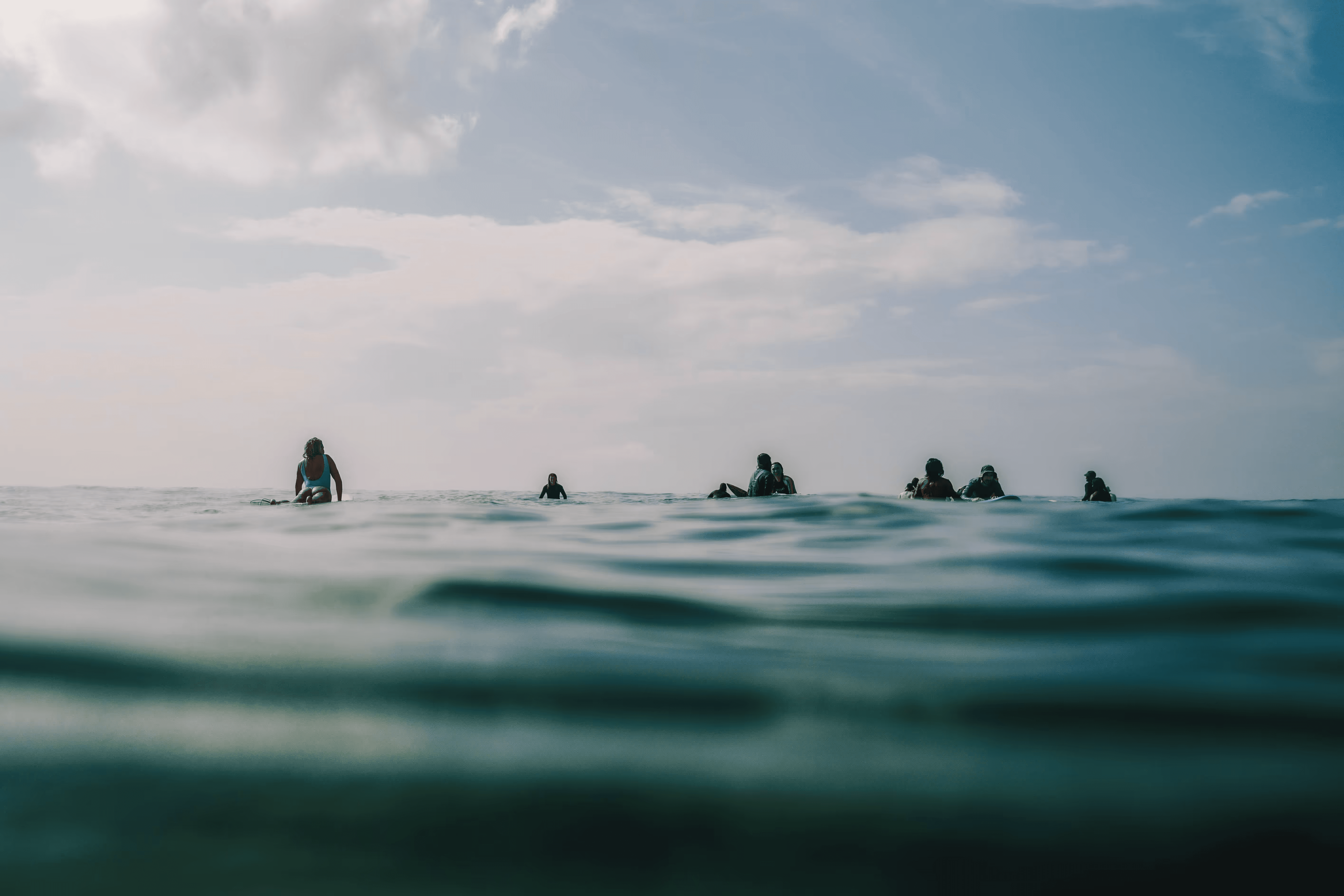 Surfers on surfboards in the ocean near the shore.