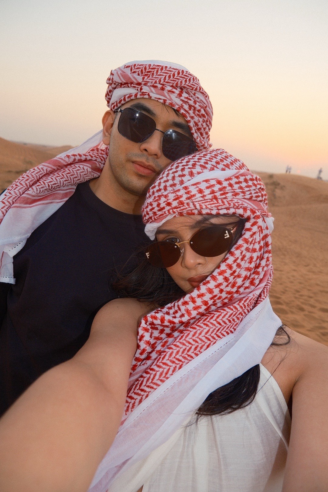 A couple enjoying a private sunset moment with Dune Quest Tours, a highlight of their luxury Desert Safari 2026 in Dubai
