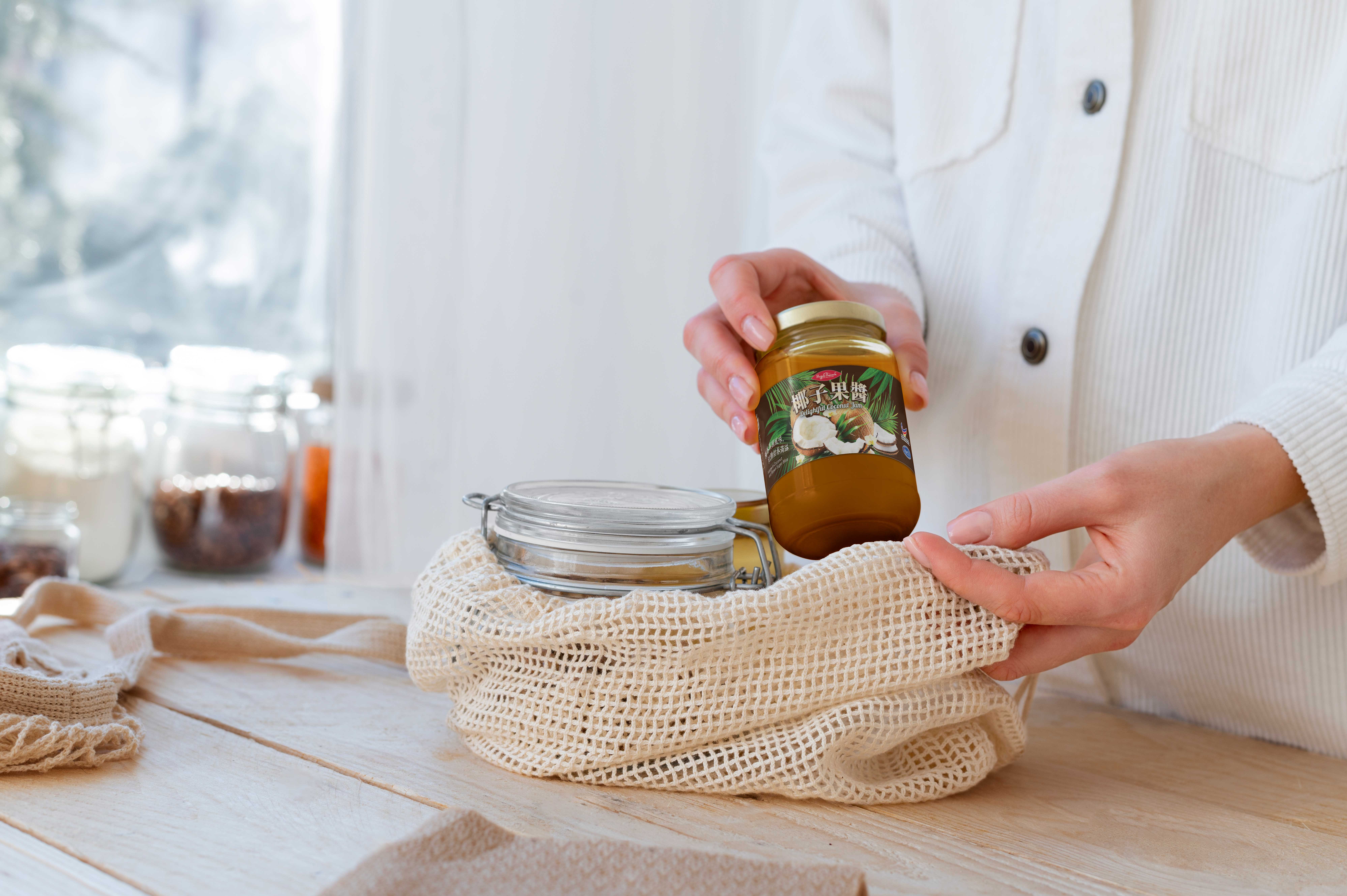 lifestyle mock up of a lady holding a jar with hajjah aminah label on it