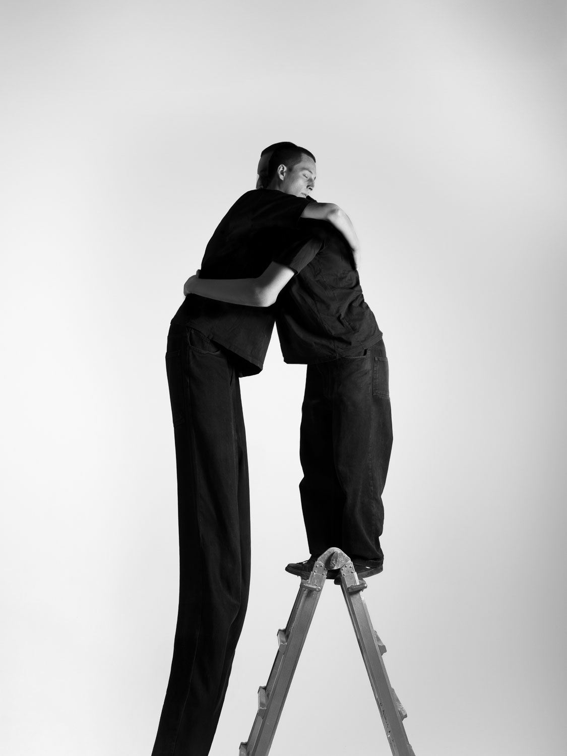 The same person hugs themselves in black and white