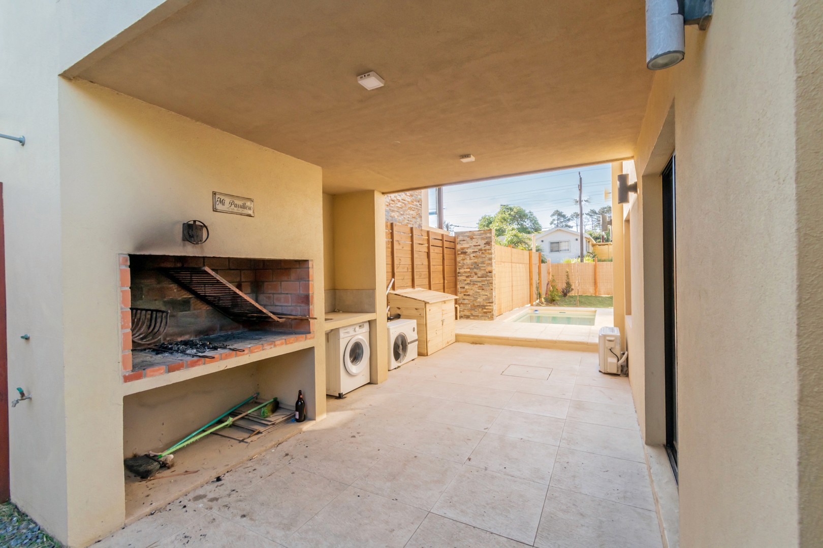 Patio trasero de Casa Horneros con parrillero cubierto - área exterior con parrilla techada para disfrutar al aire libre.